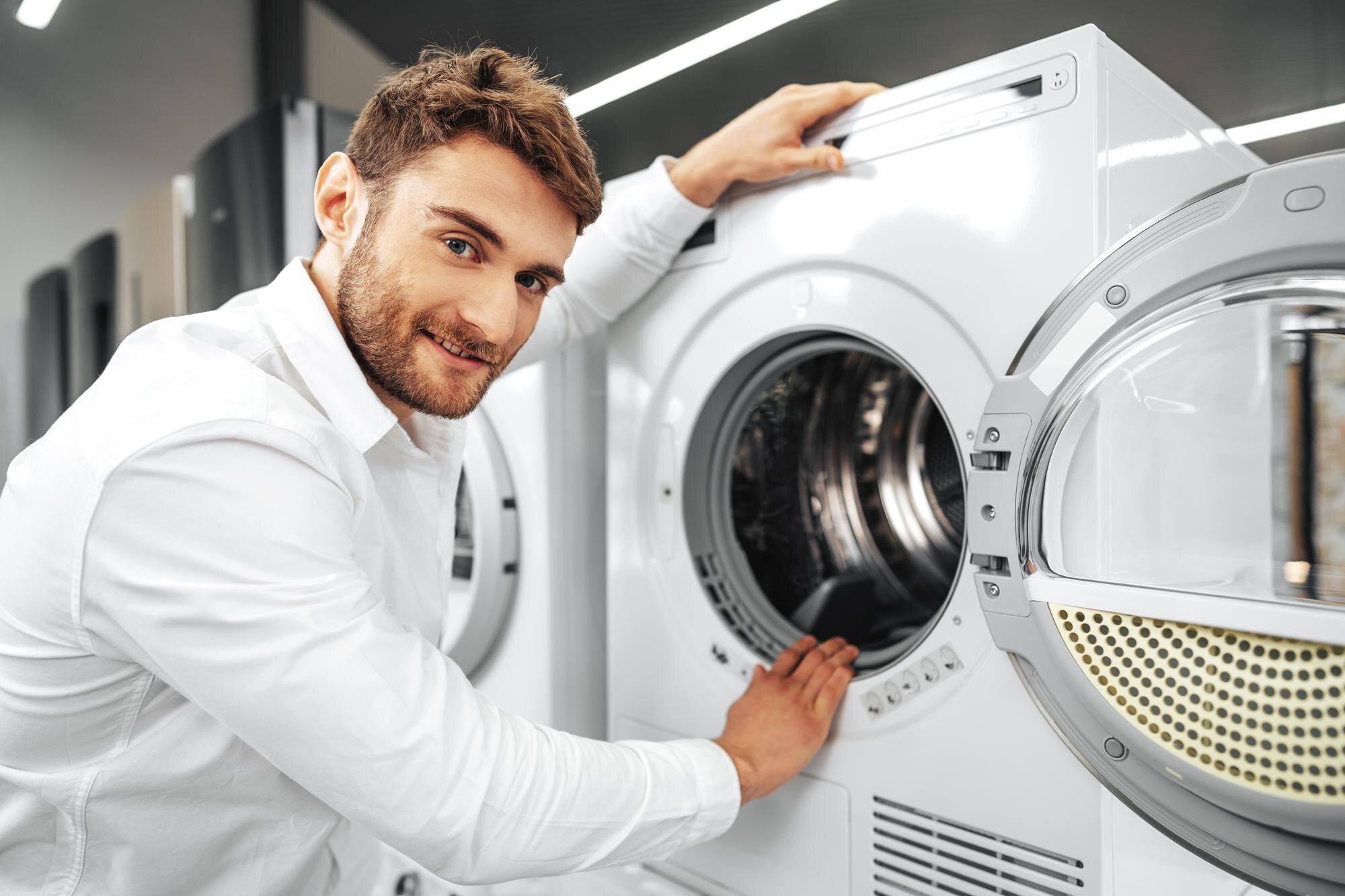 young-man-choosing-new-washing-machine-household-appliances-store_93675-133544